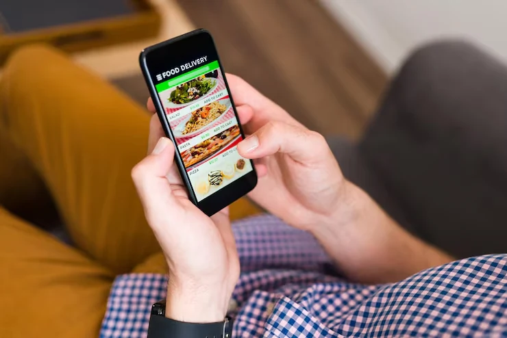 Hands holding a phone with a food delivery app open